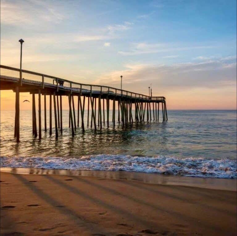 Ocean City Pier at sunrise with waves rolling onto the beach