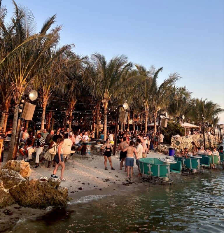 Crowd enjoying the bayfront bar scene with palm trees at Seacrets in Ocean City, Maryland