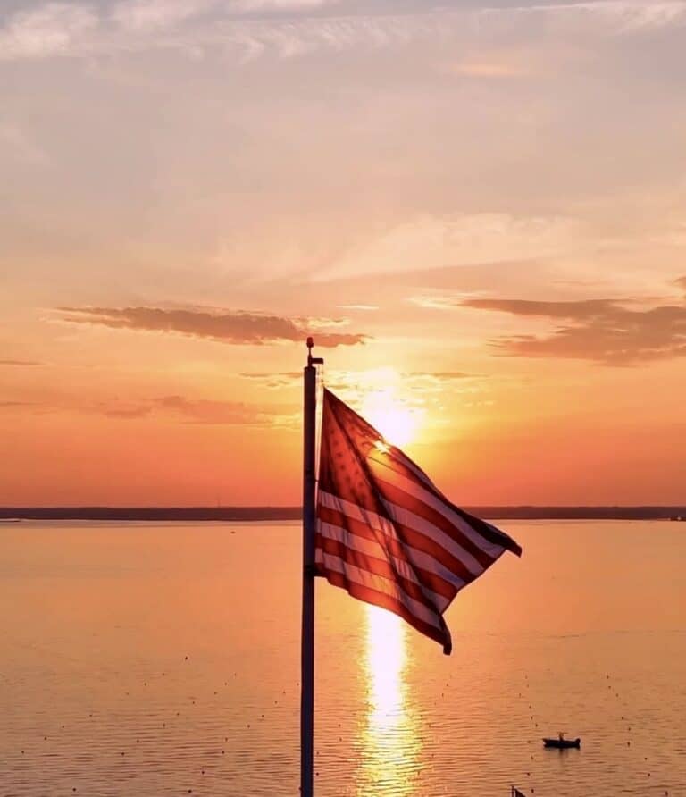 American flag silhouetted against a bayside sunset in Ocean City, Maryland
