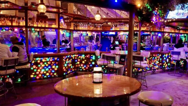 Seacrets bayfront bar complex with tiki lights and sand floors at night in Ocean City, Maryland