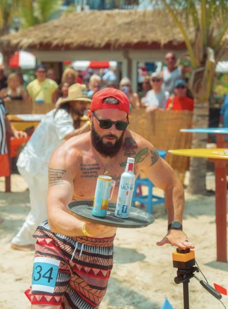 Server racing with a drink tray at Quickest Server in the Sand event at Coconuts Beach Bar in Ocean City, Maryland